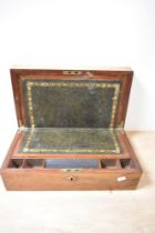 A 19th century mahogany writing slope, having internal compartments and carved escutcheon.