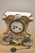 An early Victorian ceramic clock, having extensive gilt detailing with hand painted florals and