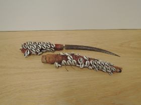 A Cowri Shell covered Dagger and Sheath, curved blade with possible engraving seen, blade length