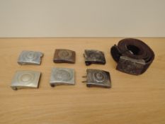 Seven German WWII period Belt buckles, one on leather belt, various and in various condition