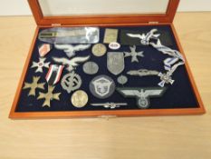 A display case containing 20+ German Badges, Cloth Badges and Medals including War Merit Medals,