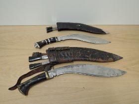 Two Nepalese Kukri's in leather scabbards each with two small knives in scabbards, sizes, blade