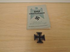 A 1939 German Iron Cross Badge and a copy of Du Und Dein Heer Taschenbuch Für Den Deutschen