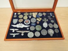 A display case containing 40+ German Badges, Medals and Stick Pins including Crimea 1941/1942