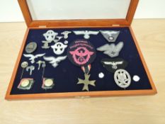 A display case containing 23 German Badges, Cloth Badges and Buttons including War Merit Medal,