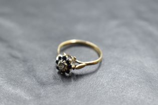 A 9ct gold diamond chip and sapphire cluster ring, of flower head form with central slightly