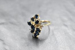 A multi stone sapphire and diamond ring having nine cascading sapphires interspersed by six