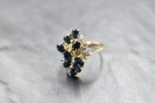 A multi stone sapphire and diamond ring having nine cascading sapphires interspersed by six