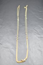 A yellow metal rope link muff chain having inset seed pearls, approx 56' & 17.9g