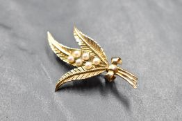 A 9ct gold brooch in the form of a tied sprig, with seed pearl buds, approx 4g