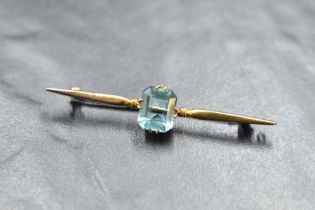 A 9ct gold bar brooch having central baguette cut blue topaz stone, approx 3.5g