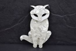 A Lea Stein brooch of a sitting cat in pearlised white and black perspex