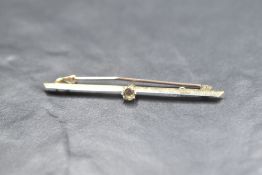 A yellow metal bar brooch stamped 18ct having central diamond, approx 0.25ct & 3.4g