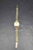 A lady's 9ct gold wrist watch by Timex having baton numeral dial to champagne face in gold case on a