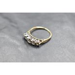 A five stone graduated diamond ring, total approx 1.25ct in a claw set raised mount on a yellow