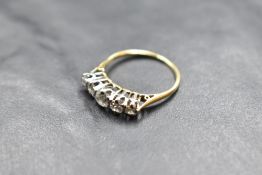 A five stone graduated diamond ring, total approx 1.25ct in a claw set raised mount on a yellow