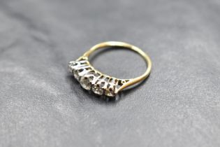 A five stone graduated diamond ring, total approx 1.25ct in a claw set raised mount on a yellow