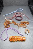 A selection of strings of beads including Baltic amber, rough cut amethyst and garnet, baltic