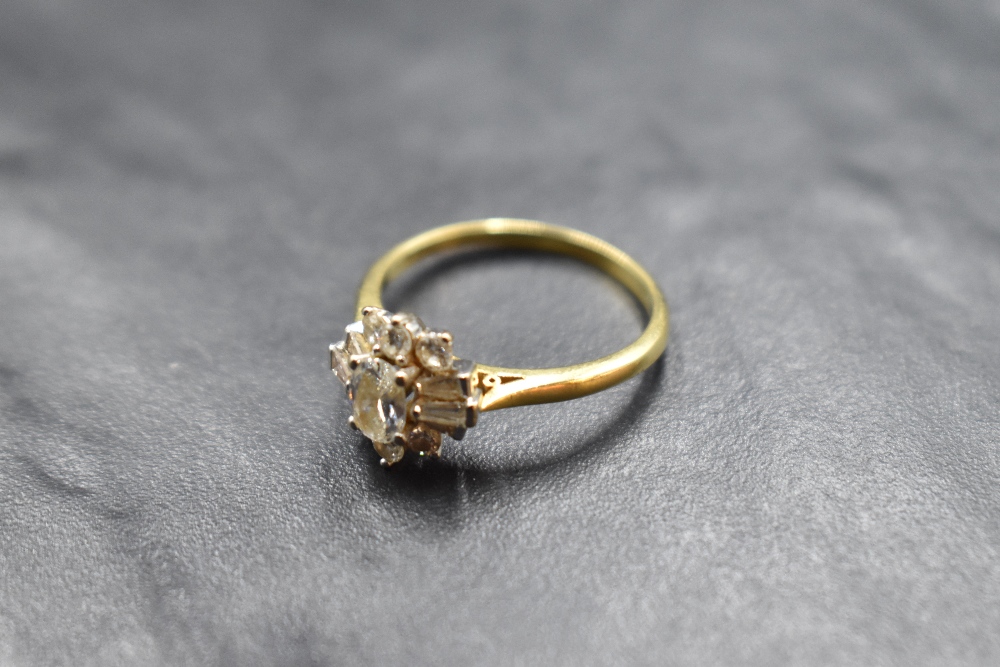 A lady's dress ring having a diamond cluster with central oval diamond surrounded by baguette and