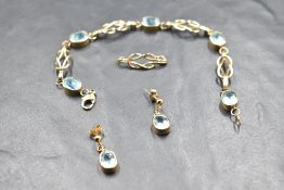 A Scottish 9ct gold articulated bracelet having five collared aqua marines, interspersed by