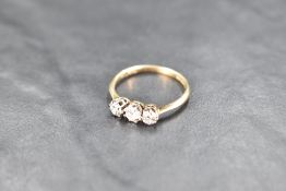 A diamond trilogy ring, total approx 0.75ct in a claw set basket mount on a yellow metal loop,