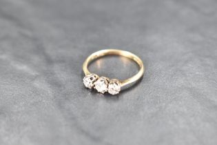 A diamond trilogy ring, total approx 0.75ct in a claw set basket mount on a yellow metal loop,