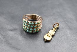 A four band interlinked yellow metal ring, each band set with six turquoise stones, marks worn, size