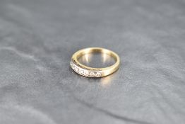 A seven stone diamond eternity ring, total approx 0.35ct in a channel set mount on a yellow metal