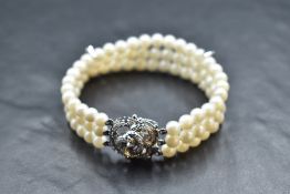 A triple row cultured pearl bracelet having two diamond set bar spacers and a 14ct white gold