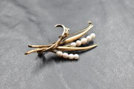 A 9ct gold and seed pearl brooch modelled as a tied sprig of flowers, approx 5.4g