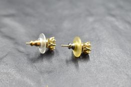 A pair of fancy pale yellow diamond solitaire earrings in yellow metal claw set mounts with ridged