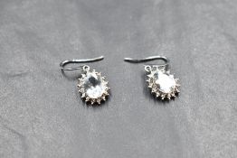 A pair of 9ct white gold earrings having loop drops to aquamarine style stones with diamond chip set