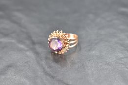 An amethyst solitaire ring having a facet cut circular stone in a collared mount on a raised star
