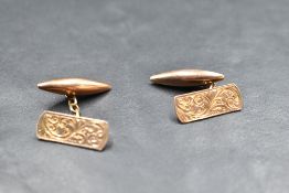 A pair of 9ct rose gold cufflinks having scroll engraved panels with chain connectors to lozenge