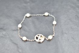 A white metal bracelet having six inset baroque pearls on a fine chain with a diamond set circular