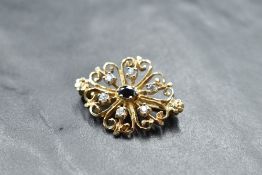 A 9ct gold brooch having central sapphire surrounded by six white stones, possibly white sapphires