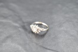 A diamond twist cluster ring having central diamond, approx 0.25ct with fanned diamond decorative