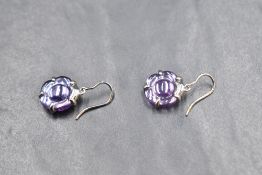 A pair of silver loop drop earrings by Baccarat having purple glass moulded discs on silver