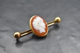 A hardstone agate cameo brooch, the oval cameo depicting a Grecian centurion in a yellow metal