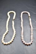 A short string of baroque pearls of pink colour having an 18ct gold clasp, approx 17' and another