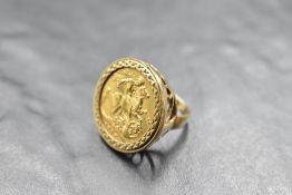 An Edwardian sovereign coin ring, dated 1907, held within a cut bezel mount and within the