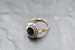 A sapphire and diamond cushion cluster having 14 diamonds surrounding an oval facet cut sapphire,