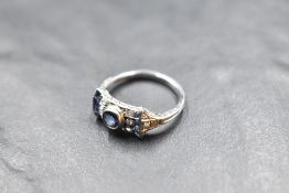 An Edwardian diamond and sapphire ring having a central powder blue sapphire within a bow style