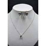 An 18ct white gold necklace by Kojis, having emerald cut aquamarine and diamond pendant with