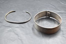 A plaited silver cuff bracelet having concealed clasp and a silver tension bangle