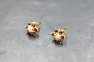 A pair of ruby and opal daisy cluster earrings for pierced ears on yellow metal