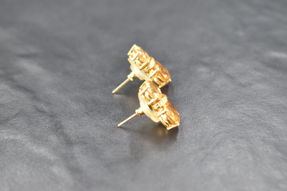A pair of double stone citrine stud earrings spaced by a row of diamond chips, all in a yellow metal - Image 2 of 3