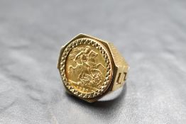 A George V sovereign coin ring, South Africa mint, dated 1930, held within a geometrically cut bezel