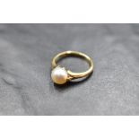 A cultured pearl solitaire ring having split shoulders and an 18ct gold loop, size G & approx 2.2g