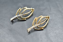A matching pair of 9ct gold open leaf brooches with diamond chip decoration to stems, (1 stone